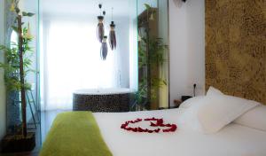 a bedroom with a white bed with red flowers on it at Hotel Boutique Sabbia Valencia in Valencia