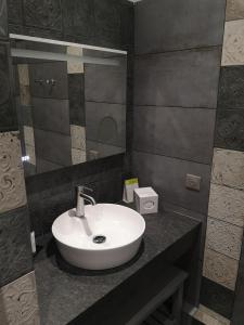 a bathroom with a white sink and a mirror at Villa Augeval Hôtel de charme & Spa in Deauville