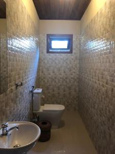 een badkamer met een toilet, een wastafel en een raam bij Paraíso Verde Arraial d'Ajuda PNM01 in Porto Seguro