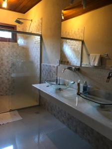 een badkamer met 2 wastafels en een douche bij Paraíso Verde Arraial d'Ajuda PNM01 in Porto Seguro