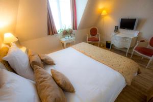 a hotel room with a large bed and a desk at Villa Augeval Hôtel de charme & Spa in Deauville