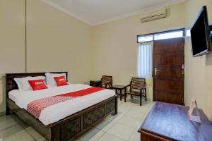 a bedroom with a bed and a flat screen tv at SUPER OYO 3862 Syariah Hotel Pandan Wangi in Sidoarjo