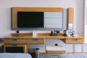 a desk with a television on a wall at Ilica Hotel Spa & Wellness Resort in Çeşme