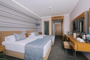 a hotel room with two beds and a desk at Ilica Hotel Spa & Wellness Resort in Çeşme