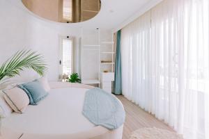 a bedroom with a white bed and a large window at Ilica Hotel Spa & Wellness Resort in Çeşme