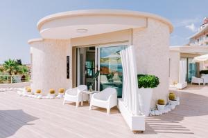 a building with white chairs and a patio at Ilica Hotel Spa & Wellness Resort in Çeşme