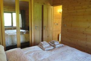 a bedroom with a bed with towels on it at Cul Darach Lodge, Glen Roy Nature Reserve in Roybridge