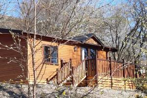 a log cabin with a porch and a deck at Cul Darach Lodge, Glen Roy Nature Reserve in Roybridge
