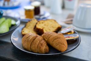 un piatto con pane e croissant su un tavolo di Alkionides Seaside Hotel a Plataniás