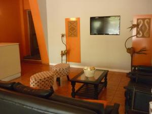 a living room with a table and chairs and a tv at Bonito Hotel in San Rafael