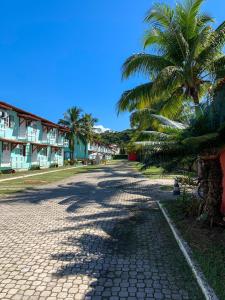 una calle adoquinada con una palmera y edificios en Apto no condomínio Taperapuan Village, en Porto Seguro