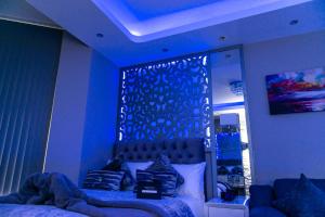 a bedroom with a bed with a blue lighting at Velmora Suites Bradford in Bradford