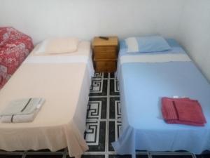 deux lits côte à côte dans une pièce dans l'établissement kitnet Maysa em Benfica RJ, à Rio de Janeiro 3 autres photos