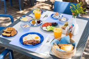 プラタニアスにあるAlkionides Seaside Hotelの朝食用の食品とドリンクの盛り合わせが備わるテーブル