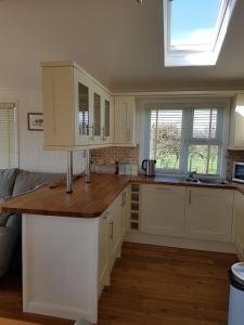 uma cozinha com armários brancos e uma bancada em Midships Lodge em Salcombe