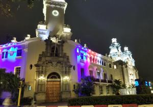 a building lit up in purple and white at Waldorf in Lima
