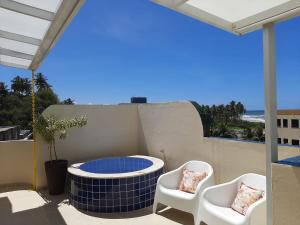 d'une terrasse avec 2 chaises et un foyer extérieur. dans l'établissement Cobertura Duplex Na Praia Dos Milionários, à Ilhéus