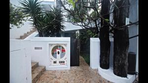 a white box with a clock next to some trees at Mi Casa en Cozumel in Cozumel