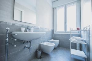 bagno con lavandino, servizi igienici e specchio di ART & BOOKS bed and breakfast a Mantova