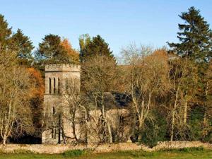 an old stone building in the middle of trees at Greystead Old Church in Hexham
