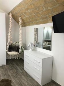 a bedroom with a white dresser and a mirror at Dimora Vittoria in Bari