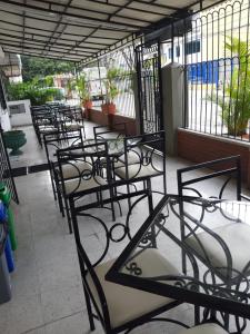 a row of empty tables and chairs on a patio at Hotel Rivera Plaza in Cali