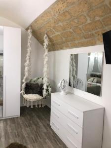 una camera da letto con altalena e specchio di Dimora Vittoria a Bari