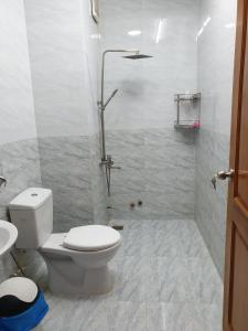 y baño blanco con aseo y ducha. en hotel đăng khôi 2 en Chau Doc