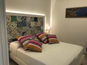a bedroom with a bed with three pillows on it at Amalfi Suite Boutique Hotel in Amalfi