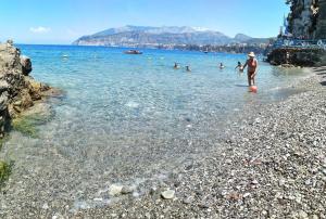 
people are swimming in the water near the beach at Hotel Desiree in Sorrento
