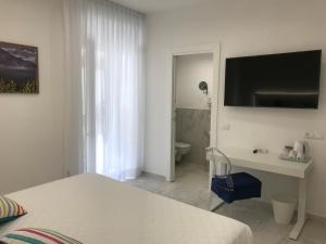 a bedroom with a bed and a desk and a bathroom at Amalfi Suite Boutique Hotel in Amalfi