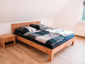 ein Holzbett in einem Schlafzimmer mit Holzboden in der Unterkunft Ferienhaus Paula in Olsberg