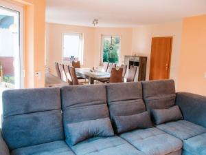 a living room with a blue couch and a dining room at Ferienhaus Paula in Olsberg