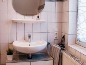 ein Badezimmer mit einem weißen Waschbecken und einem Spiegel in der Unterkunft Ferienhaus Paula in Olsberg