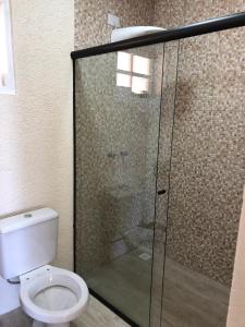 a bathroom with a toilet and a glass shower at Villa Platô in Monte Verde