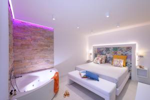 a bedroom with a bed and a bath tub next to a bed istg at Amalfi Suite Boutique Hotel in Amalfi