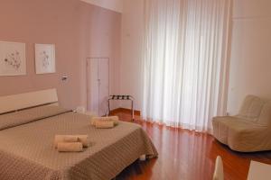 een slaapkamer met een bed, een stoel en een raam bij La Cattedrale in Ruvo di Puglia