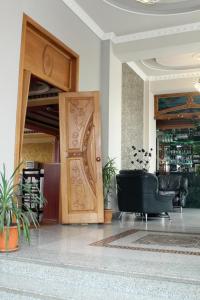 a lobby with a wooden door and a black chair at Golden Apricot in Gyumri