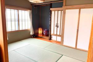 an empty room with windows and a room with a lamp at Manyi's Onsen House 天然温泉マンイの湯 in Shiraoi