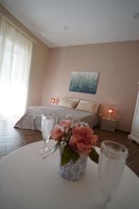 una habitación con una cama y una mesa con un jarrón de flores en La Mìmosa B&B en Nápoles