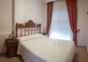 a bedroom with a white bed and a window at AZAHARA 20 in Nerja