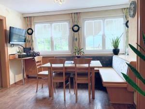 a dining room with a table and chairs and windows at Apart Laresch in Ischgl