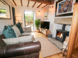 a living room with a couch and a fireplace at 1 Oakleys in Holmfirth