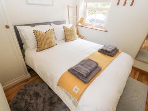 a bedroom with a large bed with two towels on it at 1 Oakleys in Holmfirth