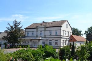a large white building with a roof at Ladiges Gasthof in Holm
