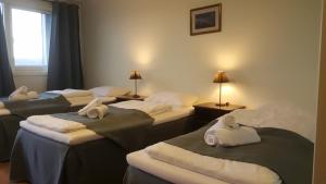 ein Zimmer mit 4 Betten und Handtüchern darauf in der Unterkunft Motell Svinesundparken in Halden
