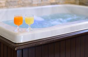 two glasses of juice sitting on top of a tub at Amalfi Suite Boutique Hotel in Amalfi