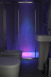 巴里的住宿－B&B Dei Cardinale，浴室配有卫生间、浴缸和紫色照明