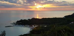 an island in the middle of the water with a sunset at La casa sul tetto, Room's & Glamping in Recanati