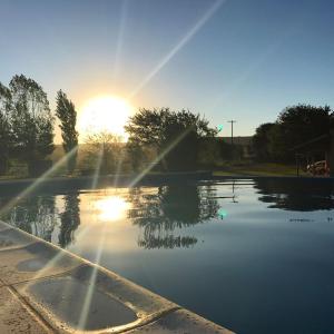einen Pool mit Wasser und Sonne im Hintergrund in der Unterkunft Casa de campo La Querencia in Villa Cura Brochero